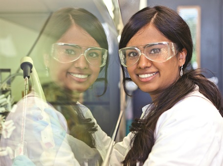 Student wearing protective gear and smiling mid-pose
