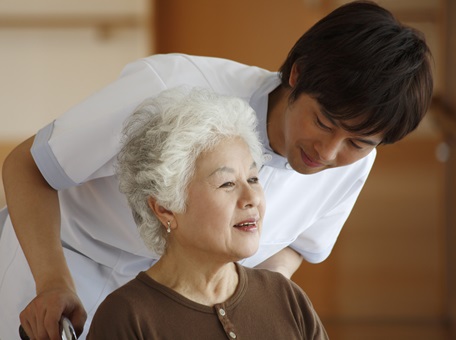 Senior woman in wheelchair with young care workers