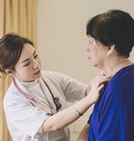 Female doctor checking on elderly female patient